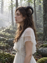 Load image into Gallery viewer, Side profile of a black curled ram horn worn by a model in a white dress in a misty forest, showing the full curl (AI-generated model image)